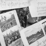 CAMBODIA, Phnom Penh. 23/05/2014: Villagers showing photographs of their eviction. About 200 people, evicted from their land in Kratie province are staying at the Samaky Reangsey pagoda since more than 1 month, waiting for a resolution of their problem by the authorities.