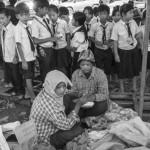 CAMBODIA, Poipet (Banteay Meanchey). 17/06/2014: Schoolchildren try to clean up the garbage left by the thousands of Cambodian migrant workers who crossed the border. In a massive movement of fear, some 180.000 cambodian migrant workers, many of them illegal, return home in one week time after the military coup in Thailand which vowed to normalise the situation of illegal immigration.