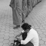 CAMBODIA, Phnom Penh. 10/07/2014: Woman preparing alms for the buddhist monks about to enter the Royal Palace on the first of a three day ceremony where the ashes of King Norodom Sihanouk, deceased on October 15th 2012 at the age of 89, are being transported from the Royal Palace to a stupa inside the compound.