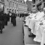 BELGIUM, Veurne (West Vlaanderen). 27/07/2014: Clergy watching the penitents carrying their cross during the procession in the streets of Veurne.