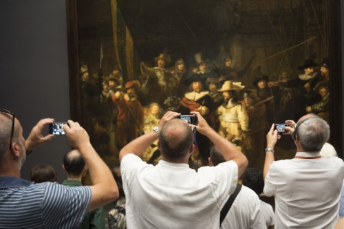 NETHERLANDS, Amsterdam. 5/08/2014: Visitors at Rembrandt's 'Nightwatch' at the Rijksmuseum.
