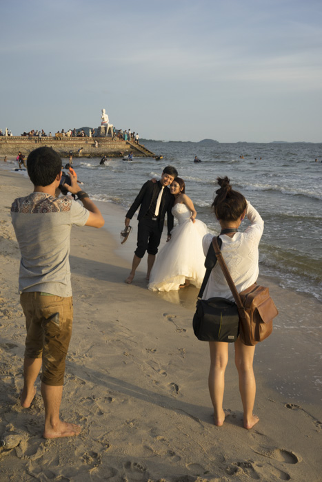 CAMBODIA, Kep. 22/09/2014: Newlyweds mingle with tourists on the beach during Pchum Ben.