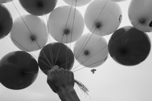 CAMBODIA, Phnom Penh. 5/10/2015: A model house attached to balloons is released when several land rights organisations gathered a crowd in front of the National Assembly of about 1000 people who are involved in a land issue to celebrate World Habitat Day.